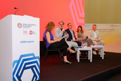 Photo of five people on a stage of a panel at the Global Sustainable Development Congress. The second person from the left is André Lindner from TU Dresden.