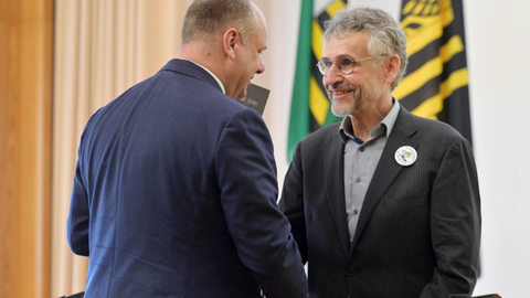 Foto von Dresdens Oberbürgermeister Dirk Hilbert, der Prof. Michael Kobel die Hand schüttelt bei der Verleihung der Ehrenmünze.