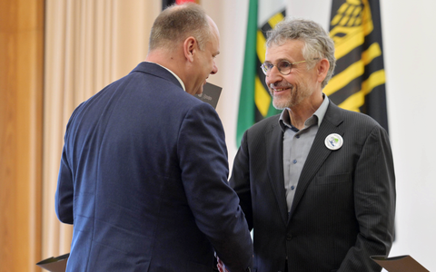 Foto von Dresdens Oberbürgermeister Dirk Hilbert, der Prof. Michael Kobel die Hand schüttelt bei der Verleihung der Ehrenmünze.