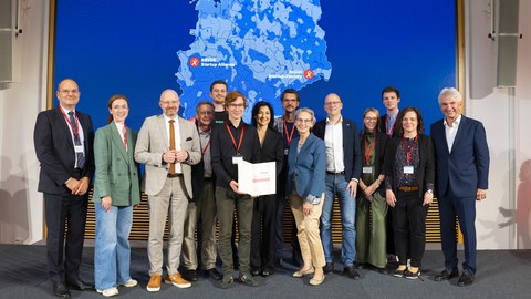 Erfolgreiche Startup Factory: Bundeswirtschaftsministerin Katherina Reiche (7.v.l.) beglückwünschte Vertreter:innen des boOst-Konsortiums. 