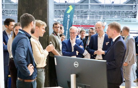 Sachsens Ministerpräsident Michael Kretschmer (r.) informierte sich bei Dr. Moritz Herzog und den Clustersprechern Prof. Gerhard Fettweis und Prof. Jochen Hampe (v.l.) an den Silicon Saxony Days.