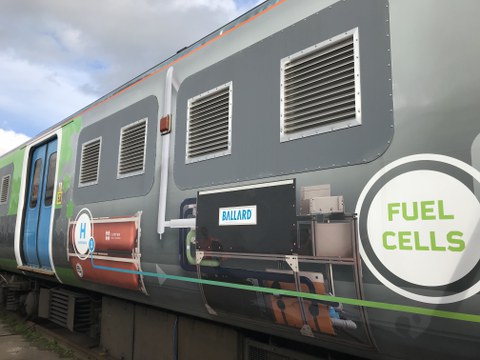 Seitenansicht eines Eisenbahnwagens mit Werbebeschriftung
