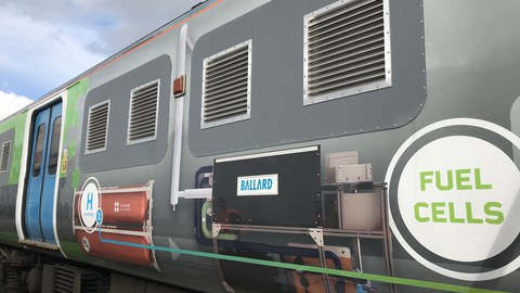 Seitenansicht eines Eisenbahnwagens mit Werbebeschriftung
