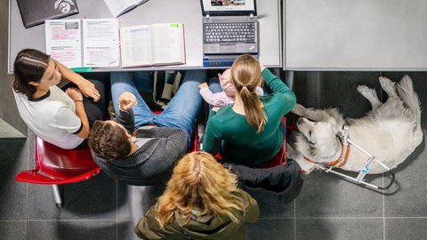 Bild mit einer Gruppe Studierender mit Kind und Blindenund.