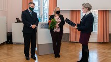 Übergabe einer Urkunde an eine Frau.