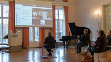 Personen verfolgen eine Präsentation auf einer Leinwand.