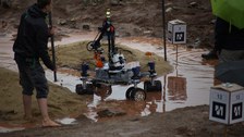 Mars-Rover auf einem Parcour aus Sand und Wasser.