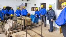 Mehrere Personen in Schutzkleidung umstehen drei Loren.