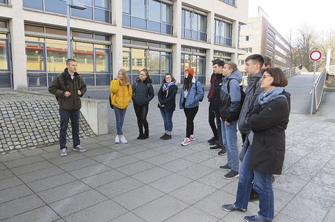 TUD-Student Florian (l.) mit einer der Schülergruppen des Herzberger Philipp-Melanchthon- Gymnasiums nahe dem Hörsaalzentrum an der Bergstraße.