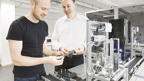 Prof. Reichelt erläutert seinem Doktoranden und Wissenschaftlichem Mitarbeiter Eric Starke den Aufbau eines Werkstückträgers.