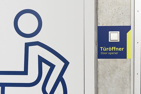 Ausschnitt mit Türöffner und Rollstuhl-Signet.
