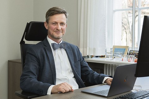 Kanzler Dr. Andreas Handschuh sitzt am Schreibtisch.