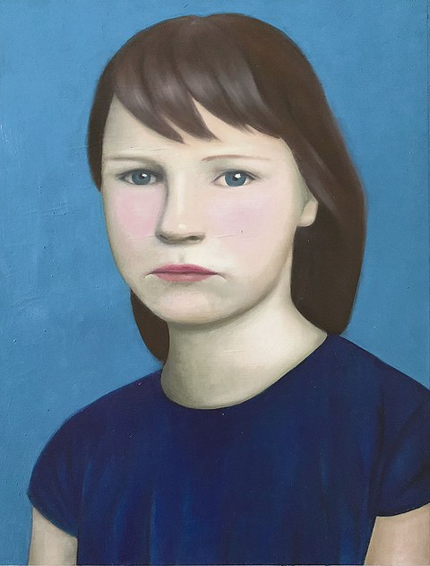 Porträt eines Mädchens, das vor einem blaue Hintergrund sitzt oder steht.
