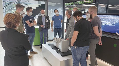 Deutsche und amerikanische Studierende mit Prof. Ullrich Hesse stehen an der Kompressoranzeige im BITZER-Hauptquartier.