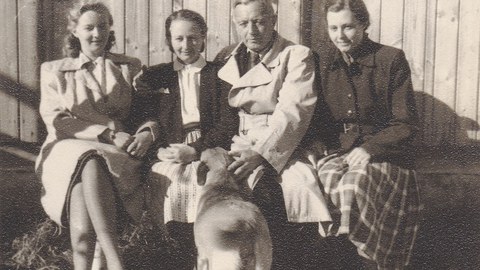 Mutter, Großeltern und Tante der Autorin sitzen nebeneinander auf einer Bank vor einem Haus. Der Hund steht davor. (SW-Foto)