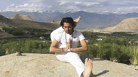 Subit Kumar Mishra auf einem Felsen. Im Hintergrund sind hohe Berge zu sehen.