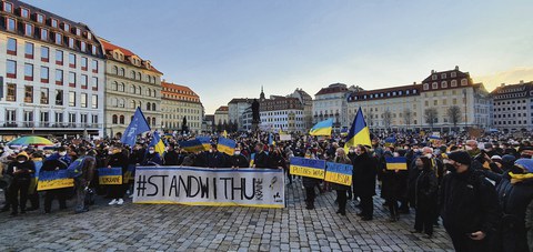Auf dem Dresdner Neumarkt demonstrieren viele Menschen. Einige tragen ein Transparente und Ukrainische Flaggen.
