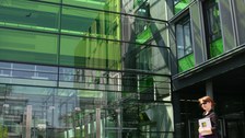 Photo of the entrance area of the Andreas-Pfitzmann Building by day. In the foreground is a woman with a cane for the blind.