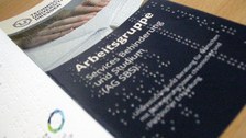 Photo of a flyer of the Working Group Services Disability and Study with Braille print.