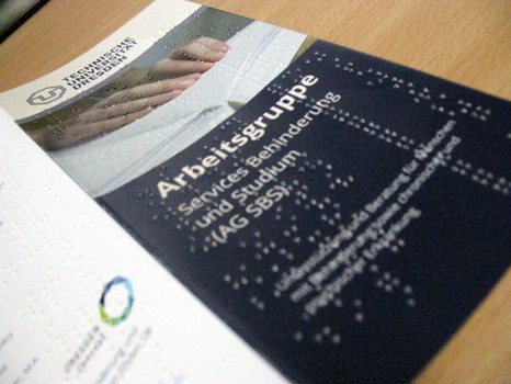 Photo of a flyer of the Working Group Services Disability and Study with Braille print.