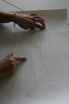 Photo of a tactile printout of a curve diagram. Two hands feel the lines of the graph.