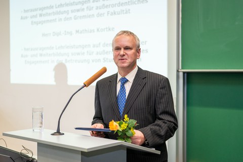 Dr. Kortke stands and speaks at a podium.
