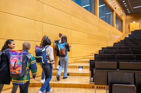 Eine Gruppe von Studenten läuft die Treppe eines Hörsaals hoch
