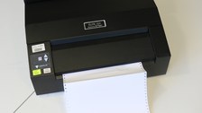 Photo shows the Elite 200 Braille printer and the continuous feed paper