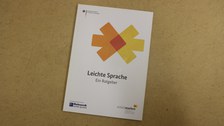 Photographed from above, it shows a copy of the Leichte Sprache guide lying on the table.
