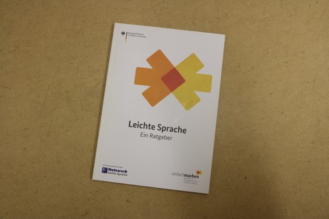 Photographed from above, it shows a copy of the Leichte Sprache guide lying on the table.