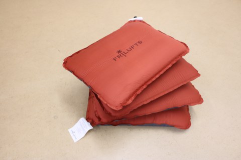 The photo shows a top view of the four red seat cushions stacked together like a fan.