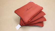 The photo shows a top view of the four red seat cushions stacked together like a fan.
