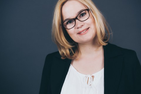 Das Foto zeigt ein Portrait einer jungen blonden Frau.