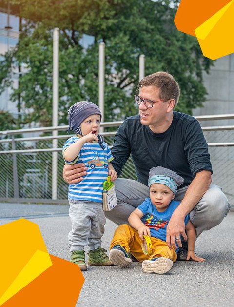 Das Bild zeigt einen Vater mit zwei Kindern.