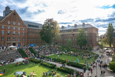 Panoramablick auf den Innenhof des Fritz-Foerster-Baus während des Familienfestes. Zahlreiche Besucher:innen sind zu sehen.