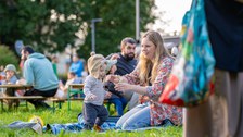 Frau mit Kleinkind auf der Wiese sitzend