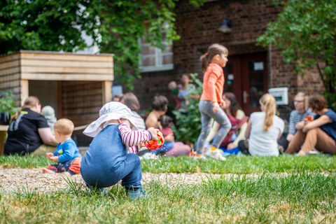 Kind spielend vor dem Campusbüro Uni mit Kind