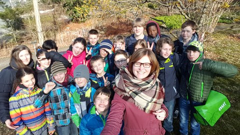 Das Foto zeigt eine Gruppe von Kindern und eine Betreuerin.
