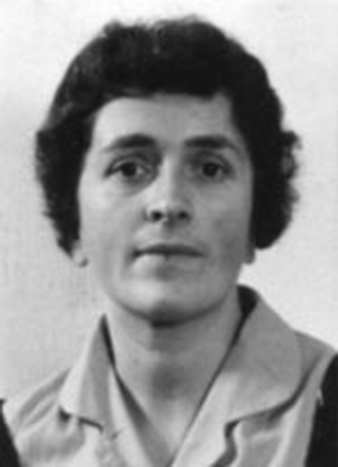 Porträtfoto einer Frau mit kurzem dunklem Haar und ernstem Gesichtsausdruck, in Schwarz-Weiß aufgenommen.