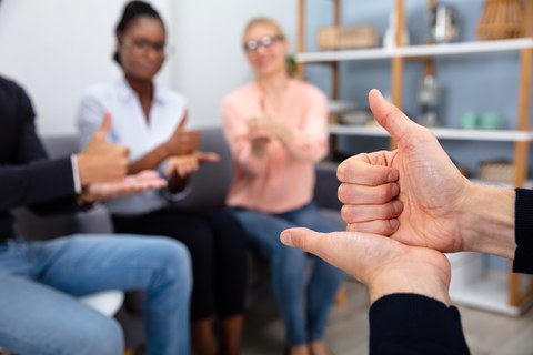 Foto mehrerer Personen, die sich in Gebärdensprache unterhalten
