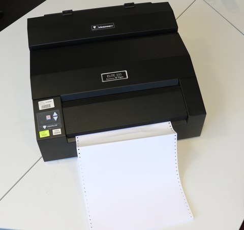 Photo shows the Elite 200 Braille printer and the continuous feed paper