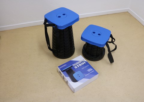 The photo shows two of the telescopic stools from above, they are set at different heights, with the packaging box in front of them.