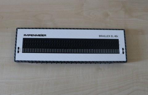 Photo shows the mobile Braille display 40 cells Braillex EL 40 c from Pappenheimer lying on the table.