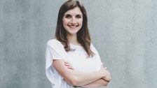 Das Foto zeigt eine junge Frau mit weißer Bluse.