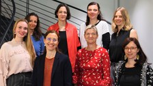Das Gruppenbild zeigt das Team Berufsbegleitende Qualifizierung von Lehrkräften an Grundschulen in Sachsen auf einer Treppe in zwei Reihen mit je vier Personen stehen.