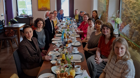 Gruppe von Professorinnen bei einem gemeinsamen Frühstück in einem Café, im Rahmen einer Vernetzungsveranstaltung, mit gedecktem Tisch und freundlicher Atmosphäre.