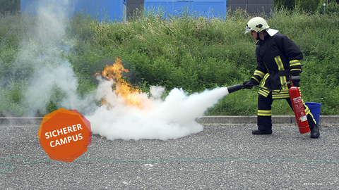 A firefighter uses a fire extinguisher to put out a fire for demonstration purposes.