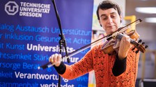 Eine Künstlerin spielt Quintone. Im Hintergrund ist ein Aufsteller der TUD zu sehen.