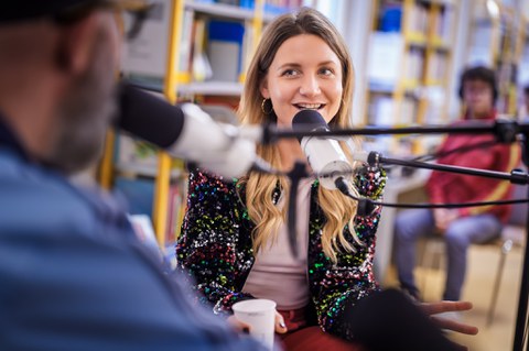 Portraitbild von Jana Forkel hinter einem Mikrofon. 