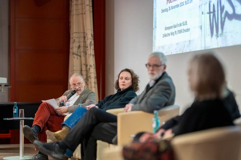 Die Podiumsgäste schauen zur Seite